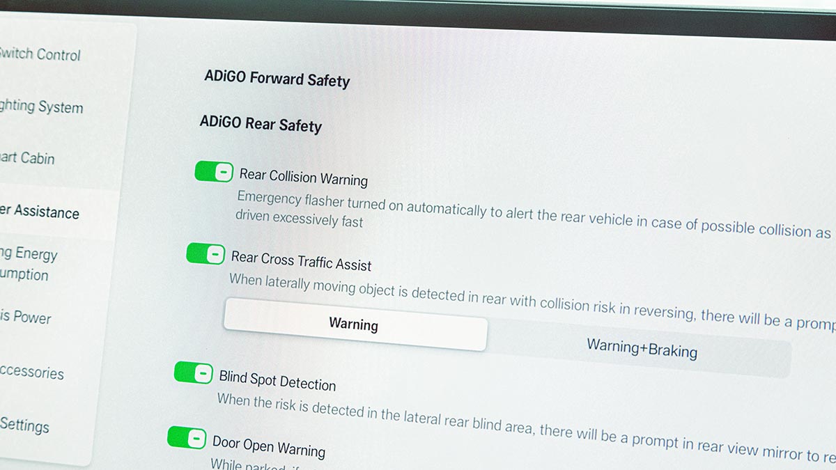Close-up of central screen on dash of GAC Aion UT showing selectable safety system settings such as rear collision warning.