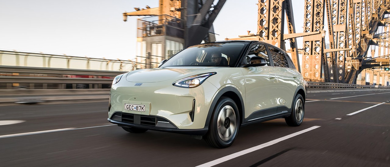 Light green Geely EX2 electric hatch driving across the Sydney Harbour Bridge.