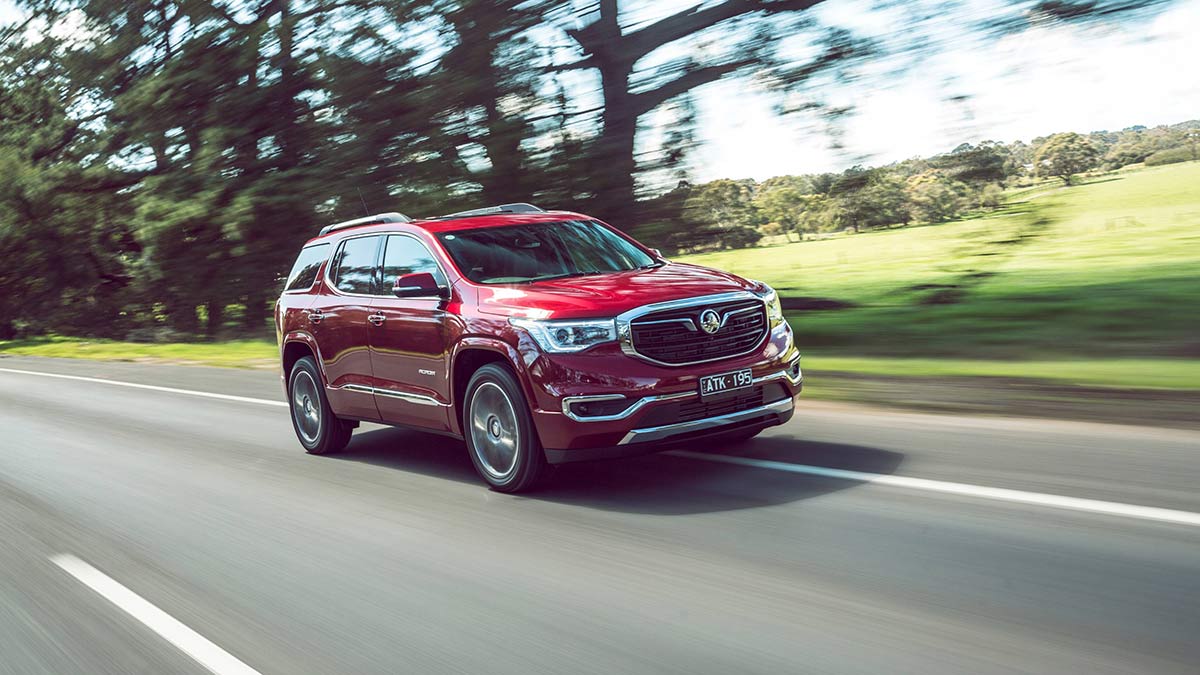 Red Holden Acadia driving on road