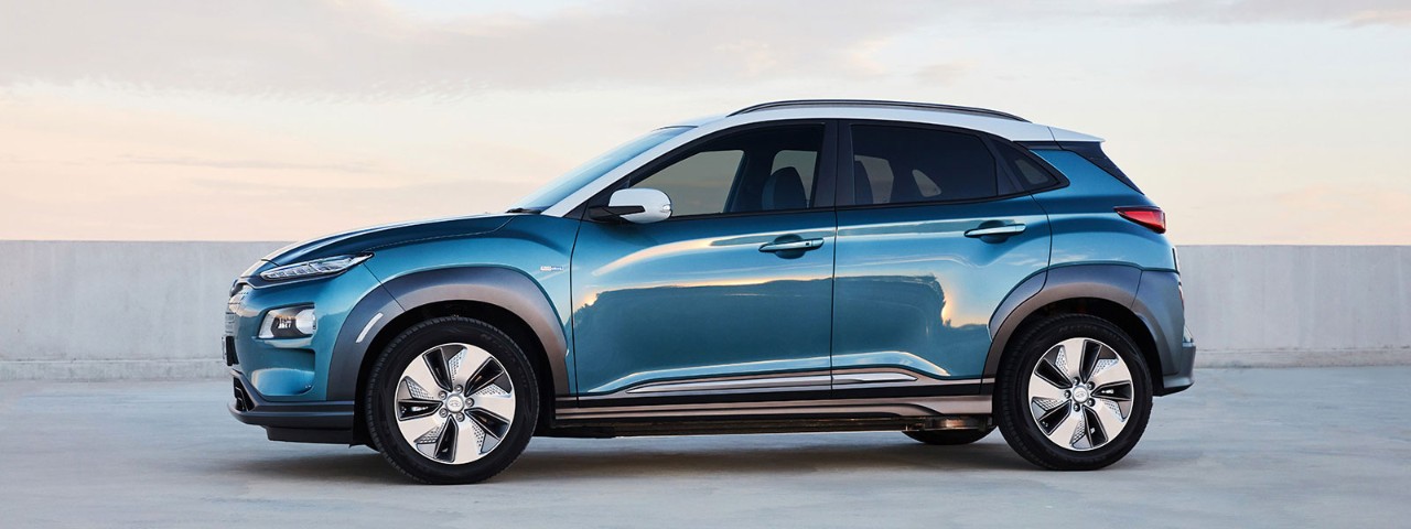 Side view of an aqua coloured Hyundai Kona Electric