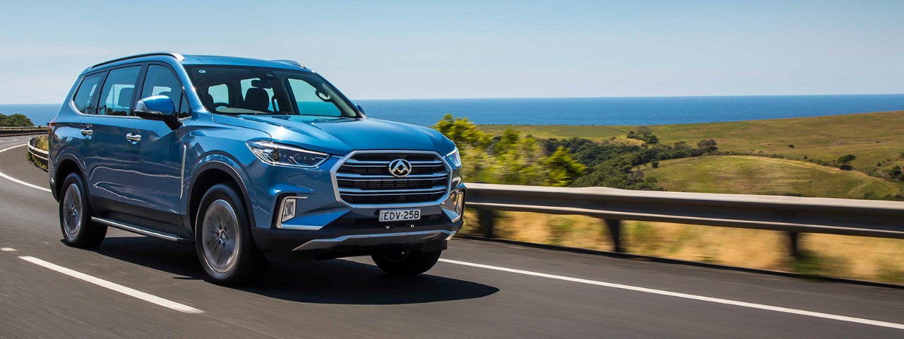 A blue LDV D90 driving on a coastal road