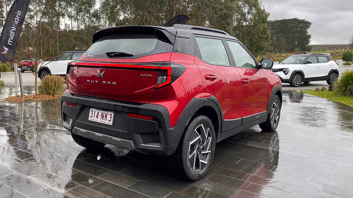 Rear end of red Mahindra XUV 3XO parked in front of two white 3XO SUVs