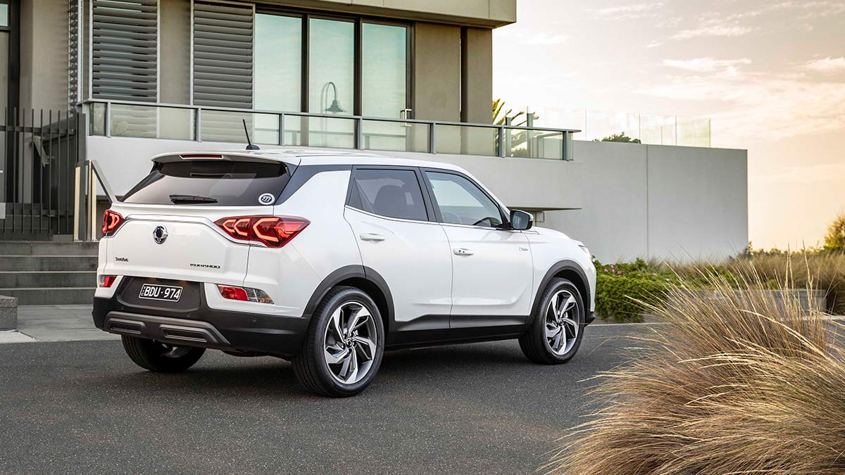 Rear side view of a white SsangYong Korando Ultimate 2020 car parked in front of a house