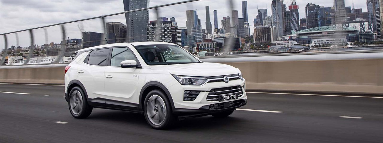Front side view of a white SsangYong Korando Ultimate 2020 car driving down a freeway