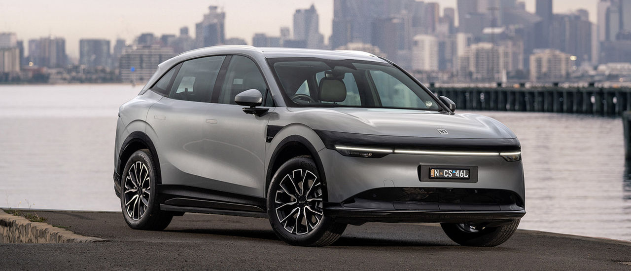 Metallic grey Zeekr 7X medium electric SUV parked at waterfront at Williamstown with Melbourne CBD behind.