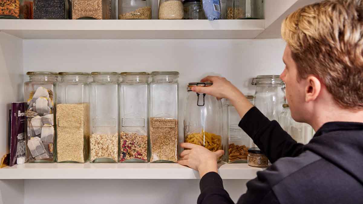 man organising kitchen pantry
