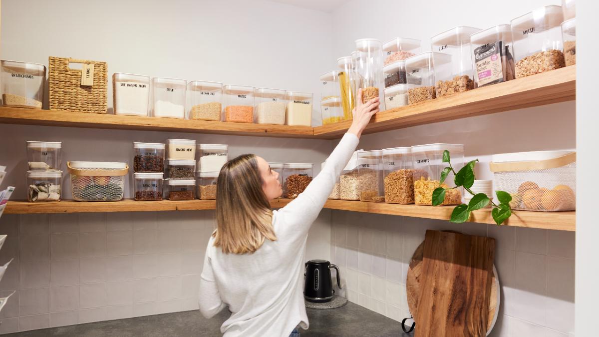 A person reaching for stored food in a pantry