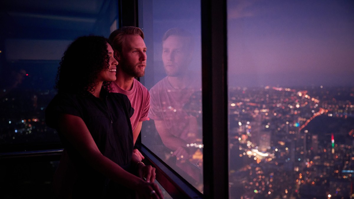 woman and man looking out of Melbourne Skydeck at the views