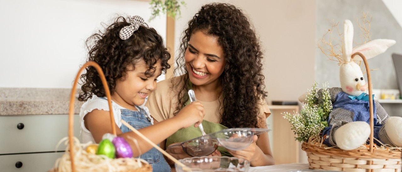 mother and child baking together with Easter decorations nearby