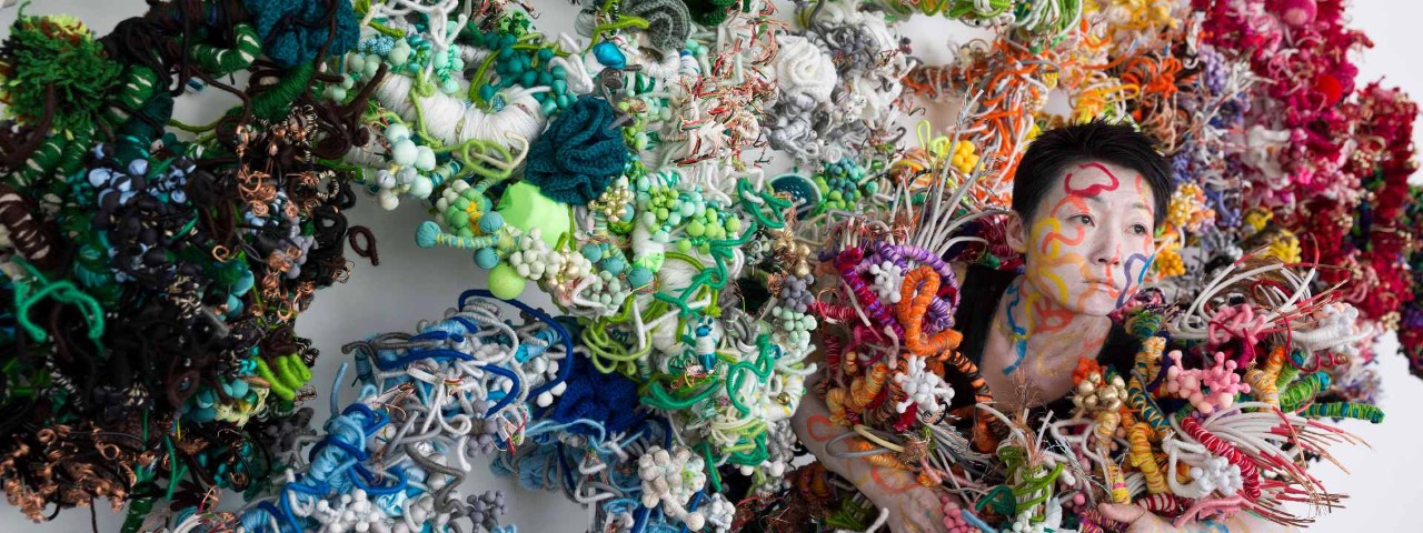 Artist Hiromi Tango entwined in her colourful soft sculpture creations
