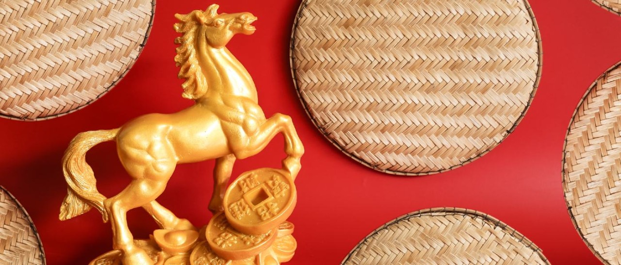 gold horse statue with traditional Chinese coins on a red background