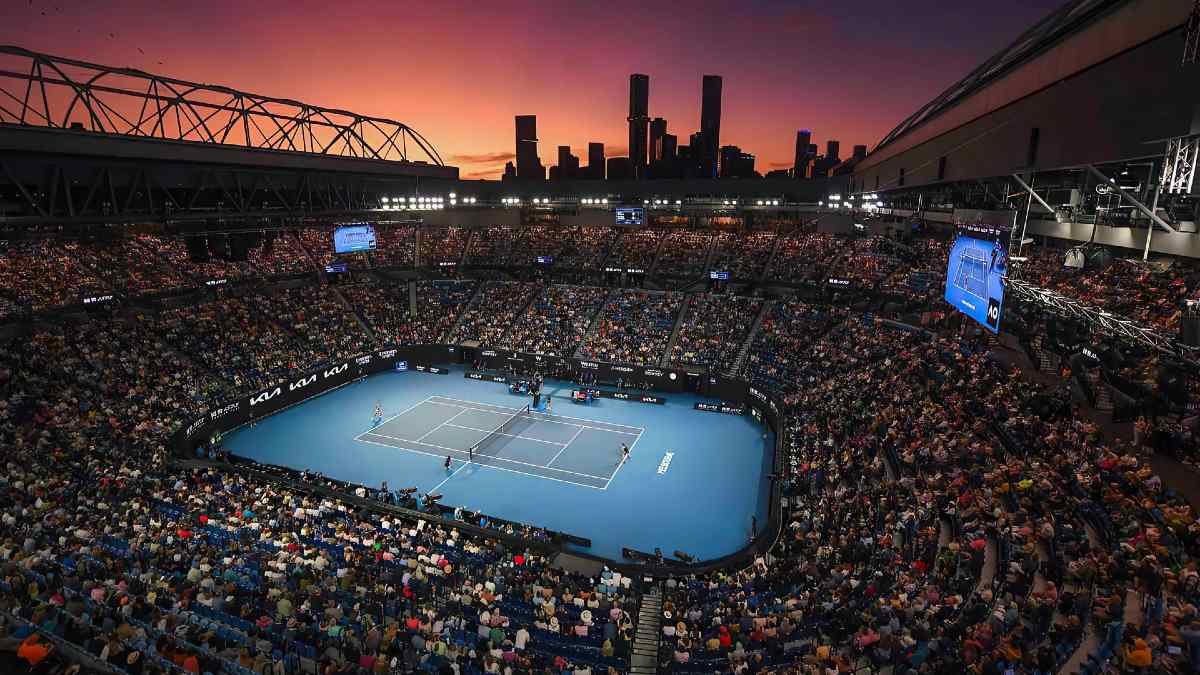 A packed Rod Laver Arena watching a sunset tennis match as part of the Australian Open