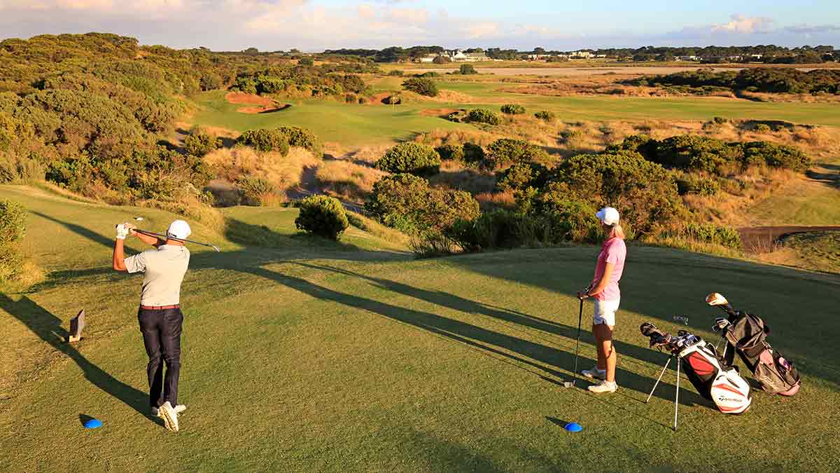 Two people playing golf at 13th Beach Golf Course at Barwon Heads in Victoria.