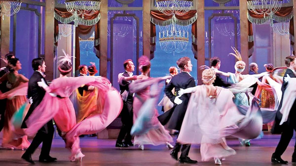 actors dancing on stage set in the early 1900s