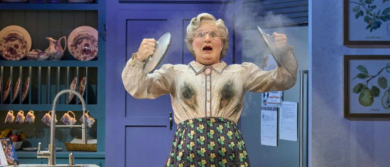 Mrs Doubtfire gasping in kitchen with burned blouse holding pot lids