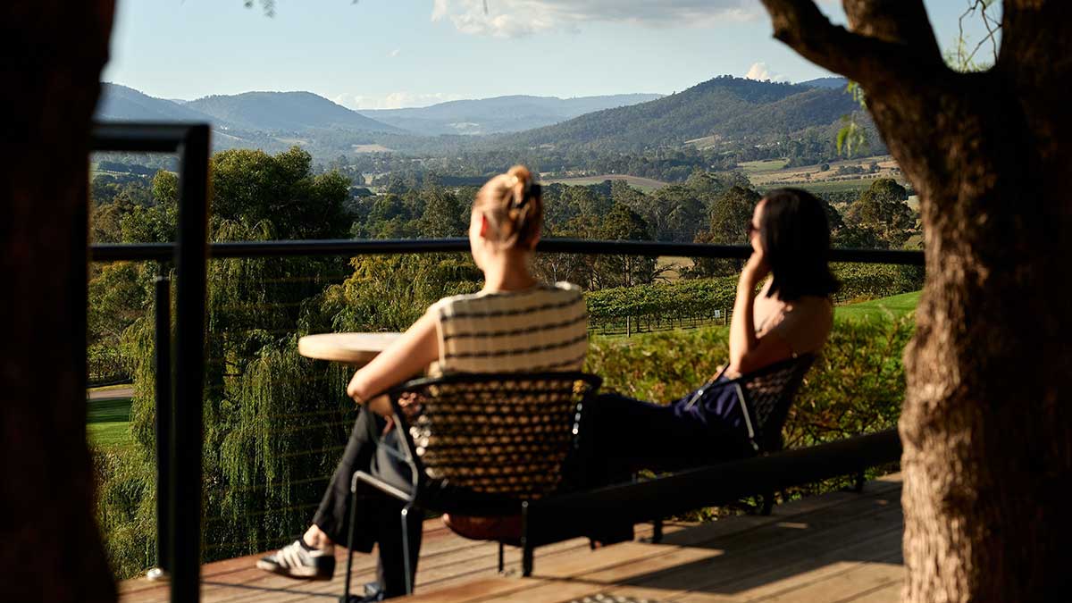 Two women admire the view from the grounds of the TarraWarra Museum of Art and winery.