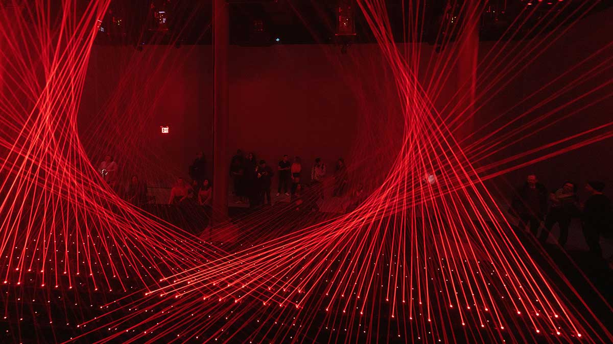 A red light installation with audience in the background