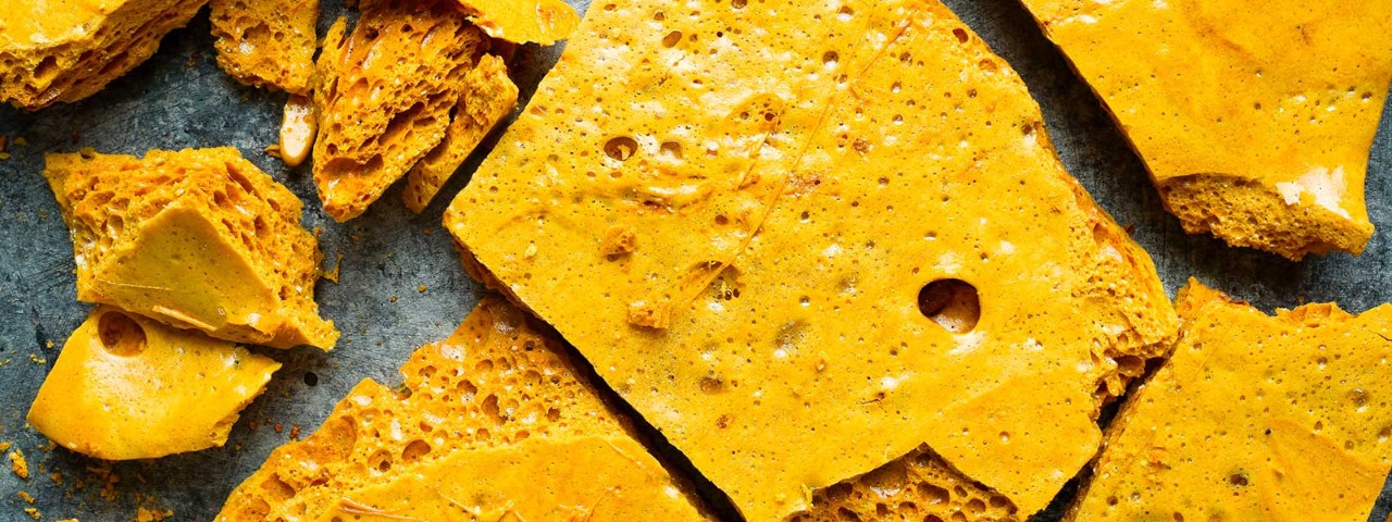 964212156 honeycomb and honey dipper on a wooden plate on a white table