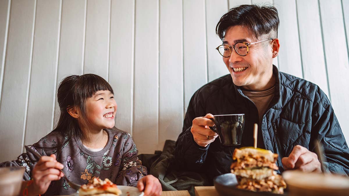 Father and daughter enjoying a meal in a cafe.