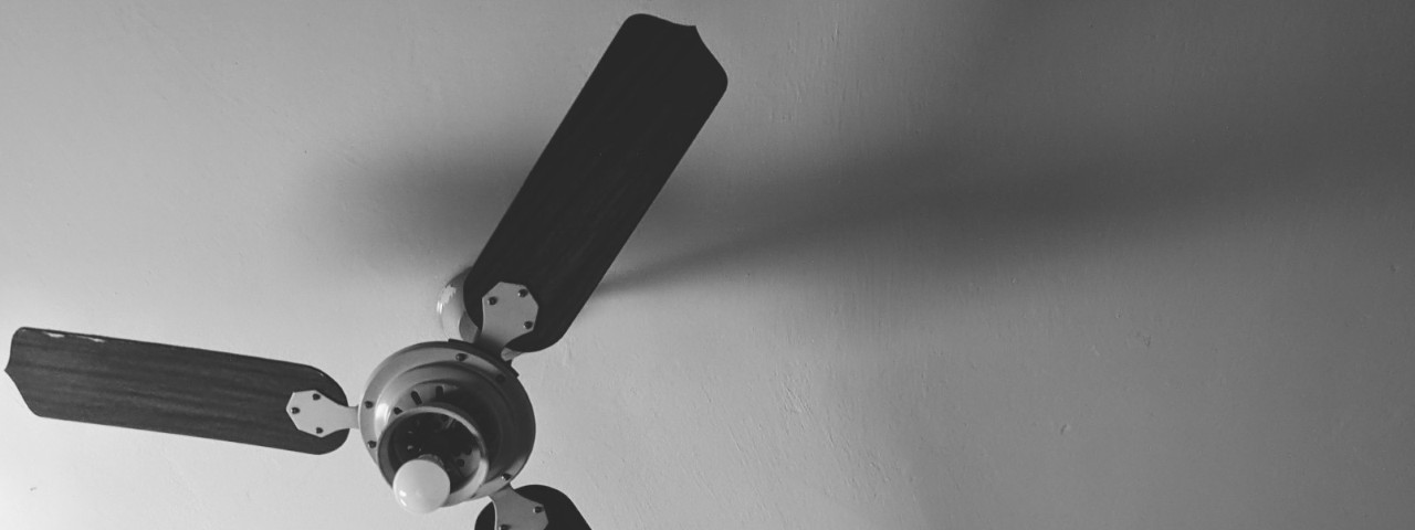 black ceiling fan on white roof