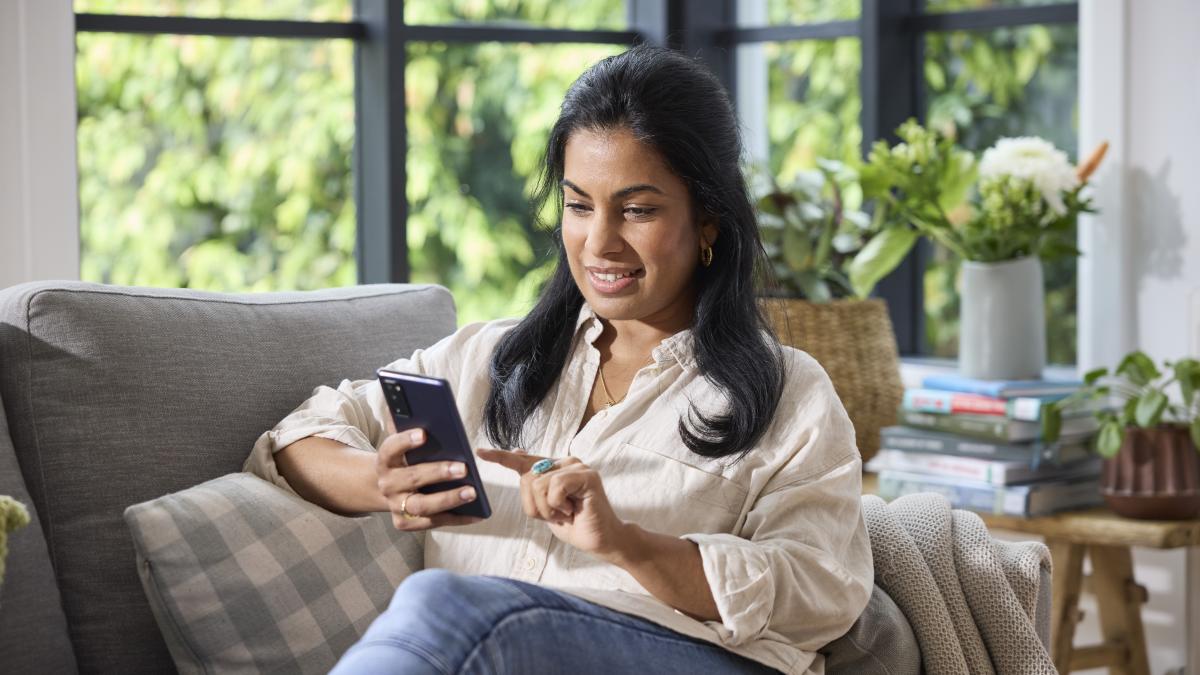 A woman relaxing on a couch while using her phone