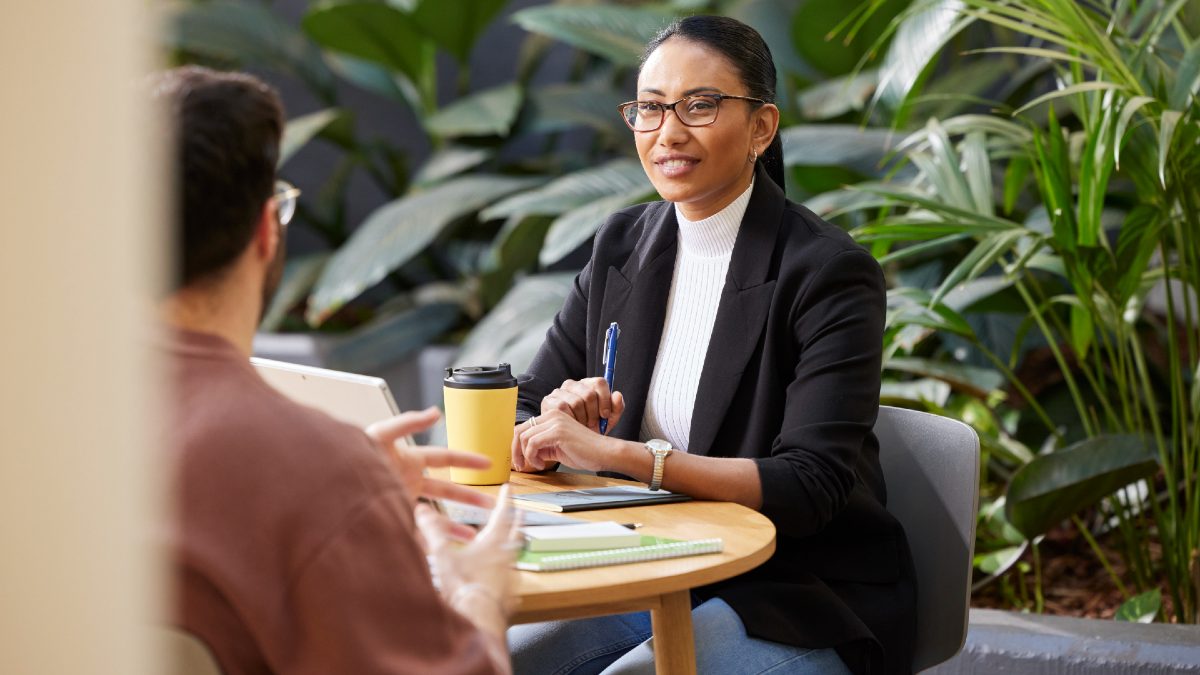 professional looking woman talking to client while taking notes