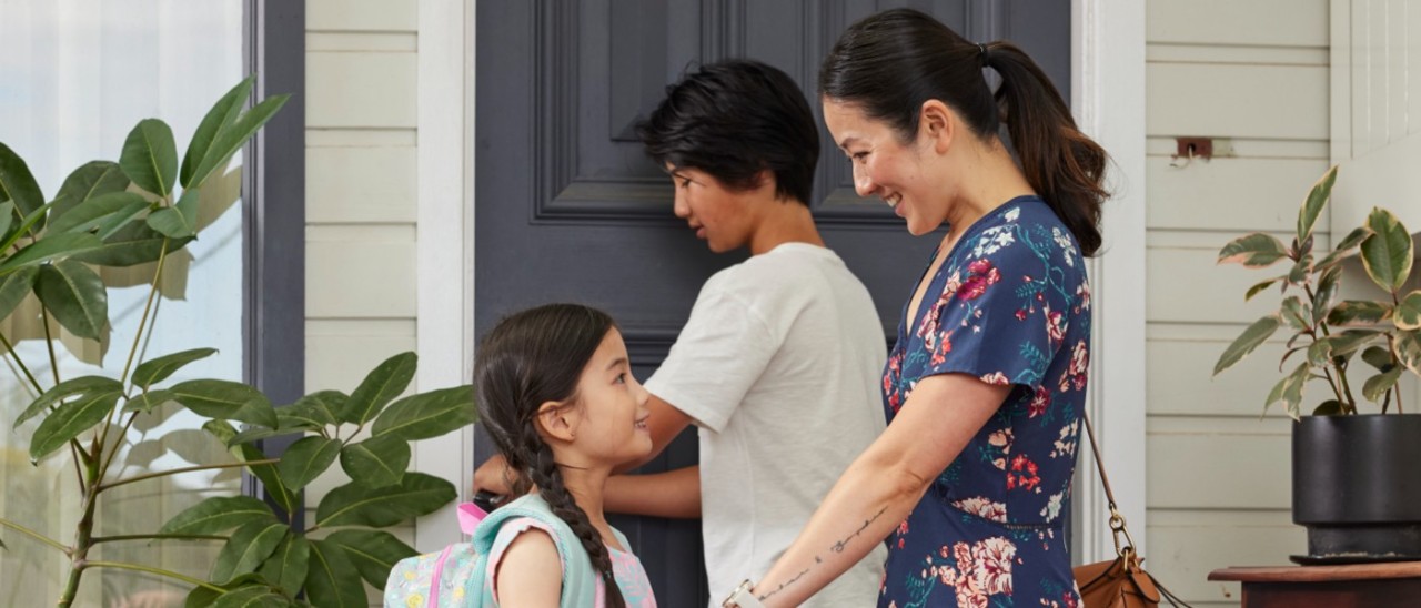 young family of three outside their home