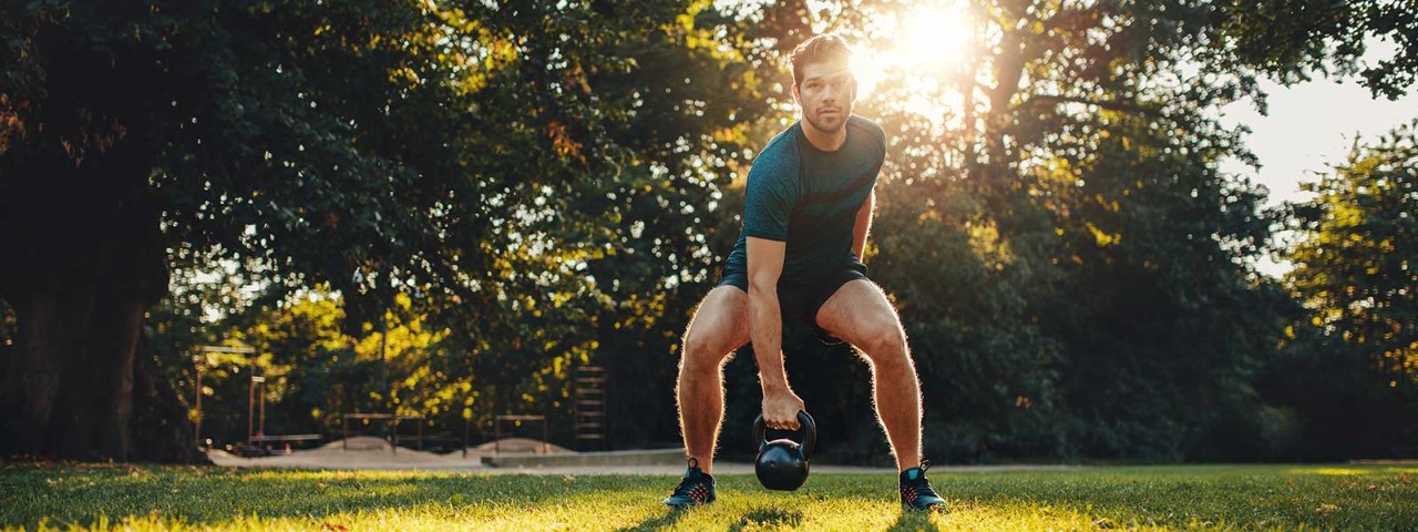 637321470 Man exercising outside using kettle bella