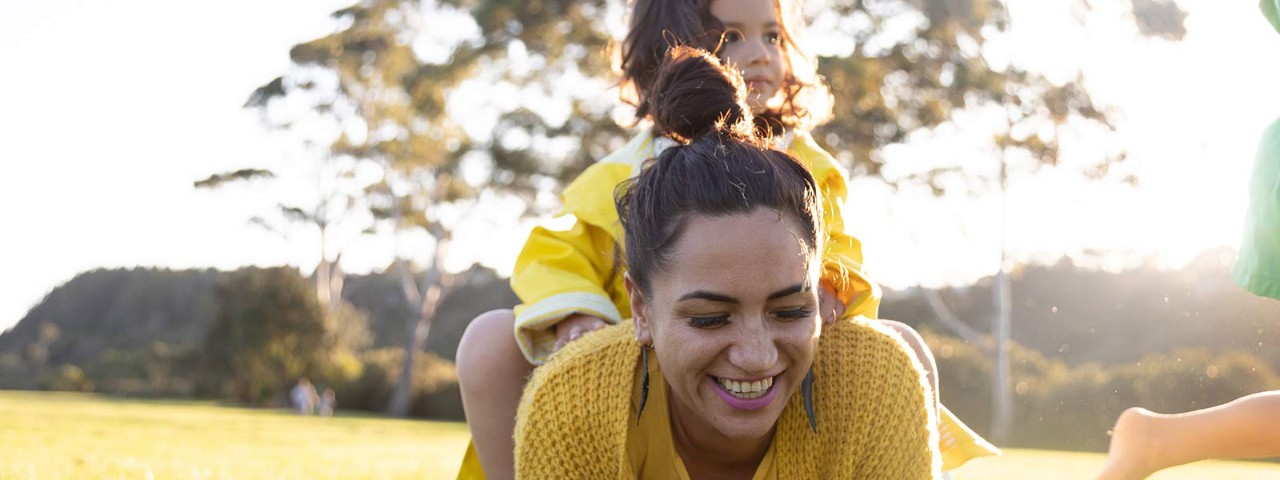 Mother and child smiling on grass