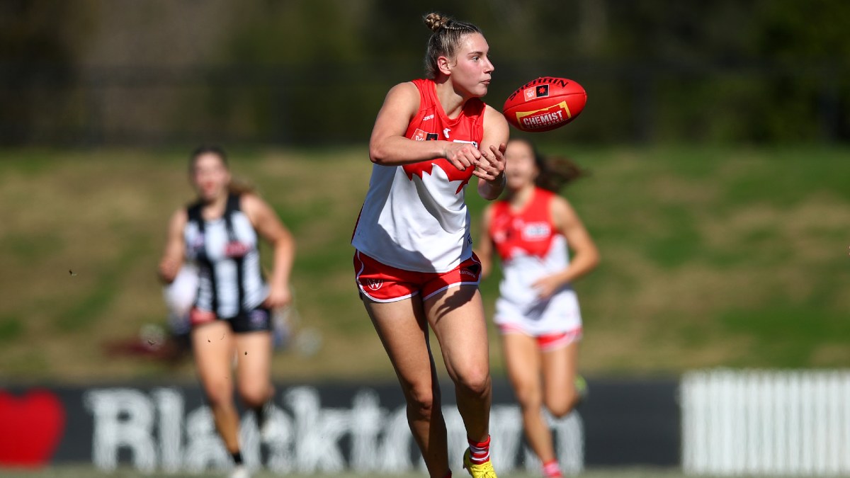 AFLW player Montana Ham handballing a footy