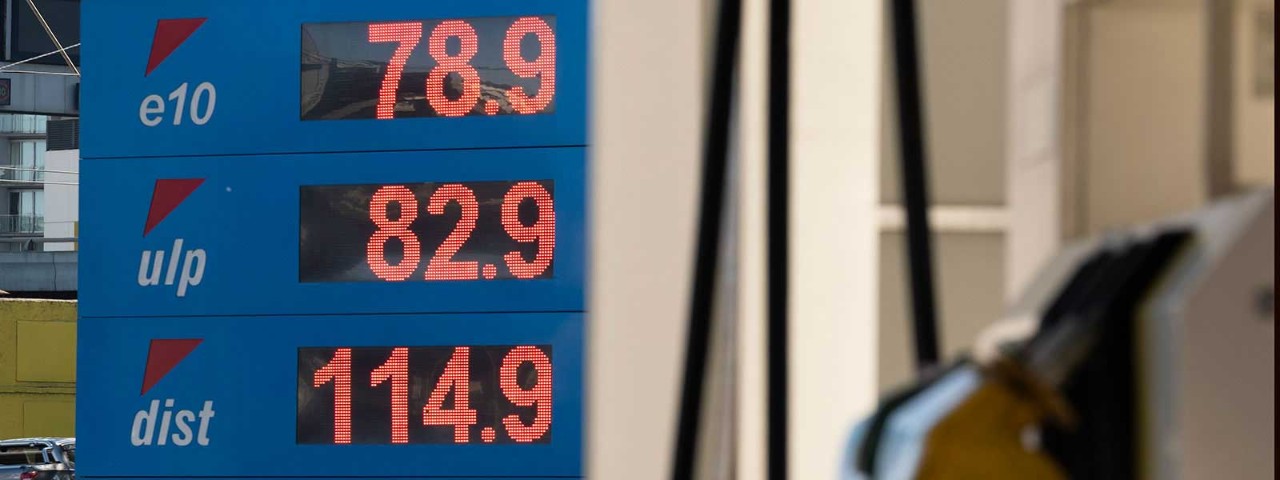 Petrol price sign with pump in the foreground.