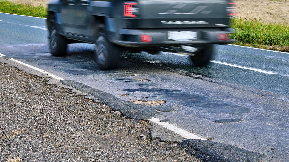 A ute driving over a potholed section of the Loddon Valley Highway