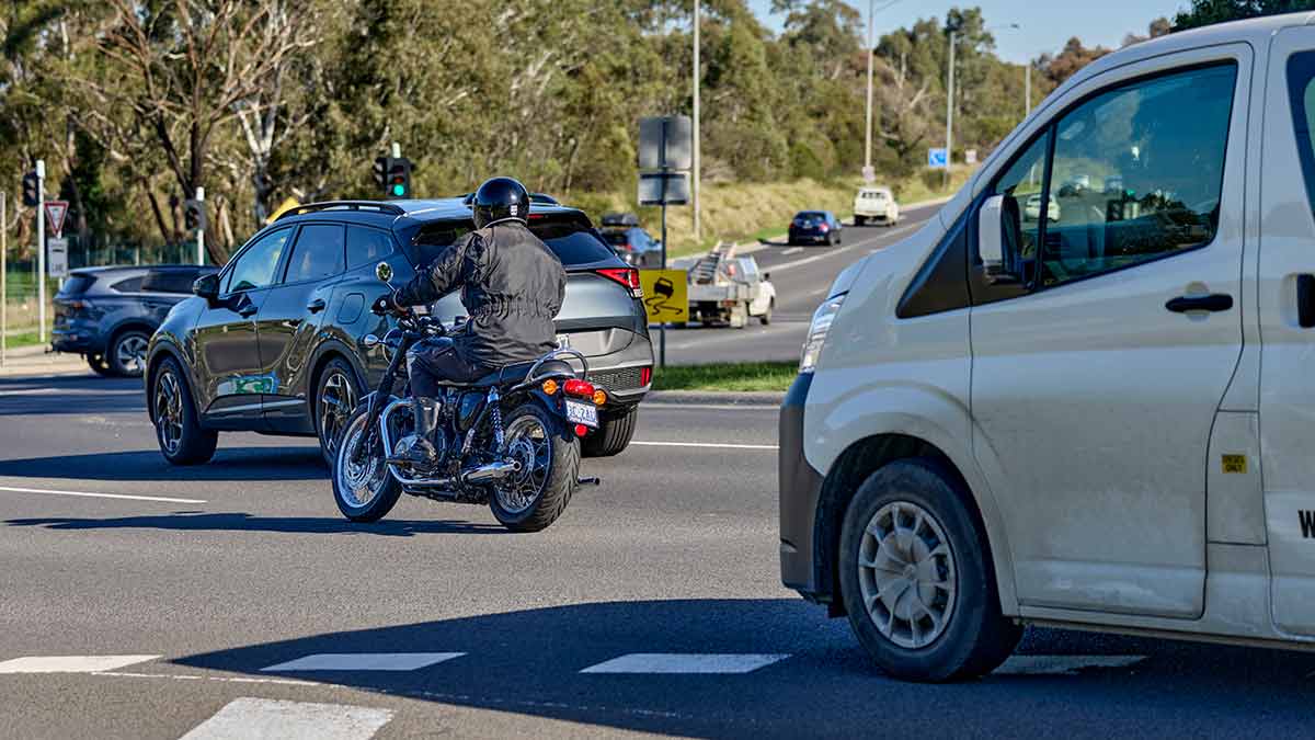 Car, motorcycle and van approaching roundabout
