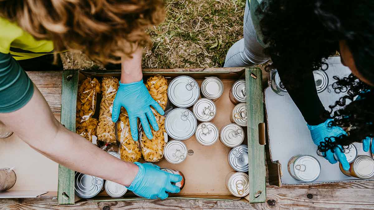Box being filled with donations of pasta and tinned food to relief centre.