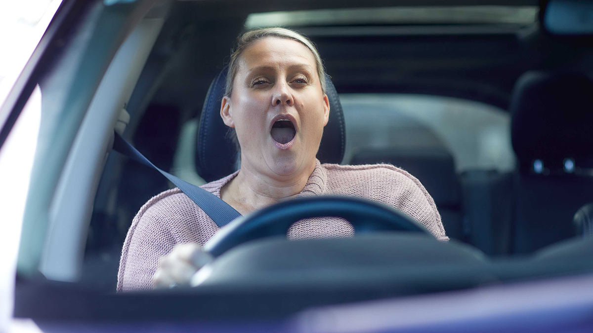 Woman yawning while driving