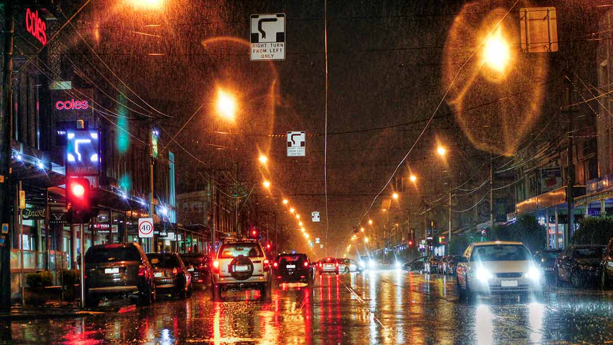 Cars driving on wet roads at night in Melbourne CBD