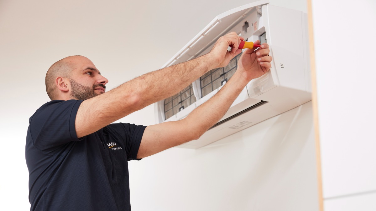 RACV electrician working on air conditioning unit