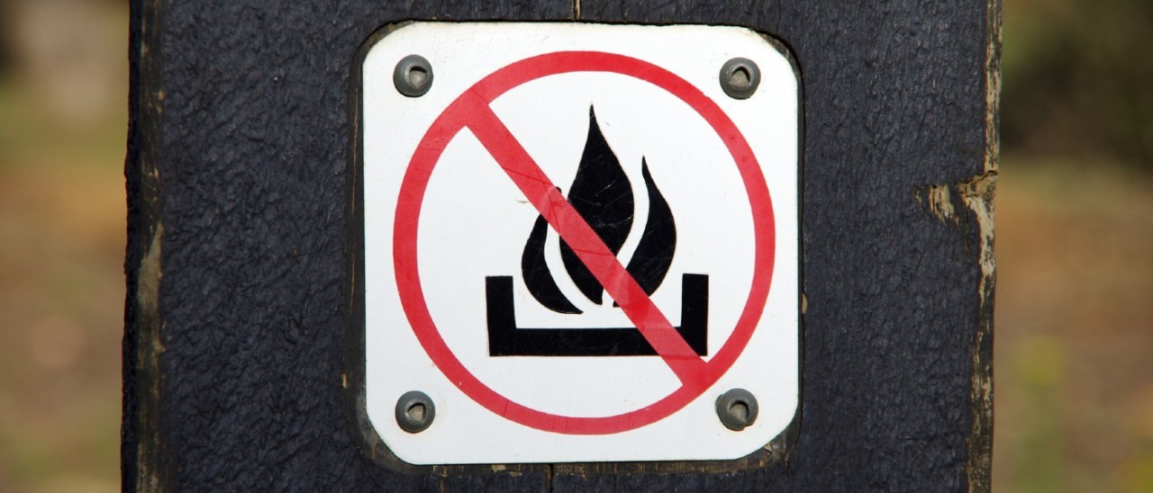sign on post of a fire with a cancel sign
