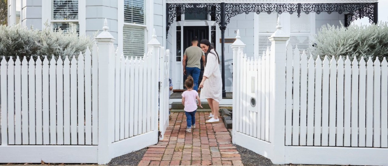A family with a young child entering a house