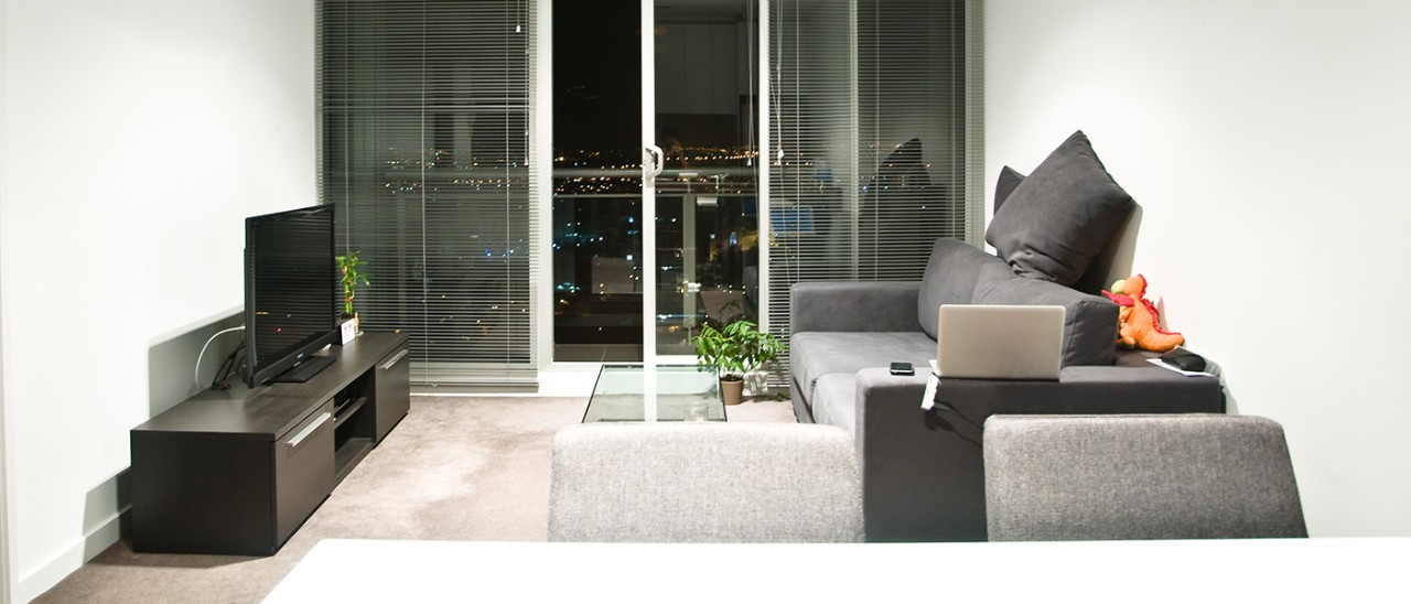 New apartment lounge with view of city at night in Melbourne, Victoria, Australia.