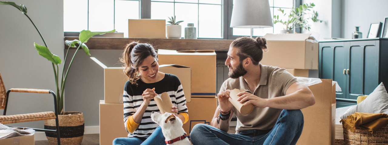 couple and dog eating with moving boxes