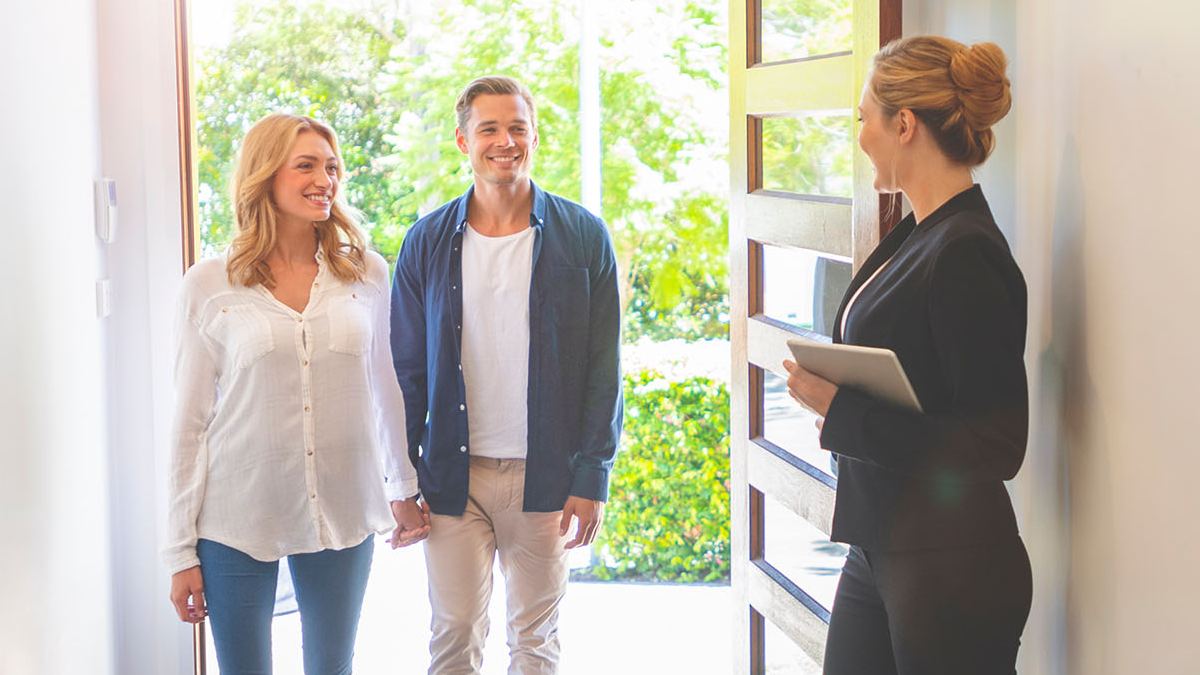 real estate agent and two people at a home open
