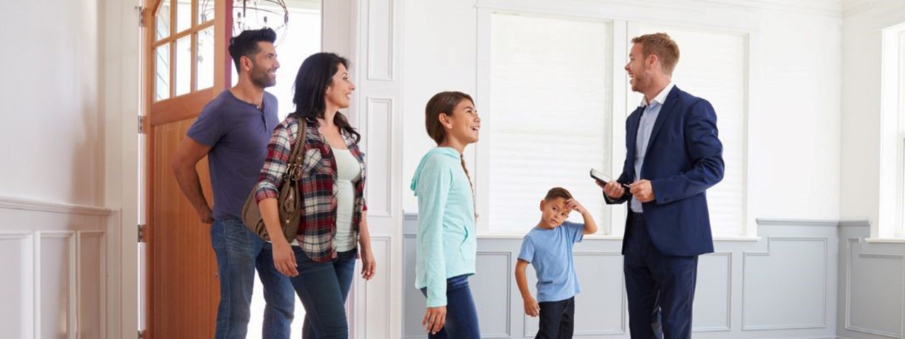 real estate agent with family showing house