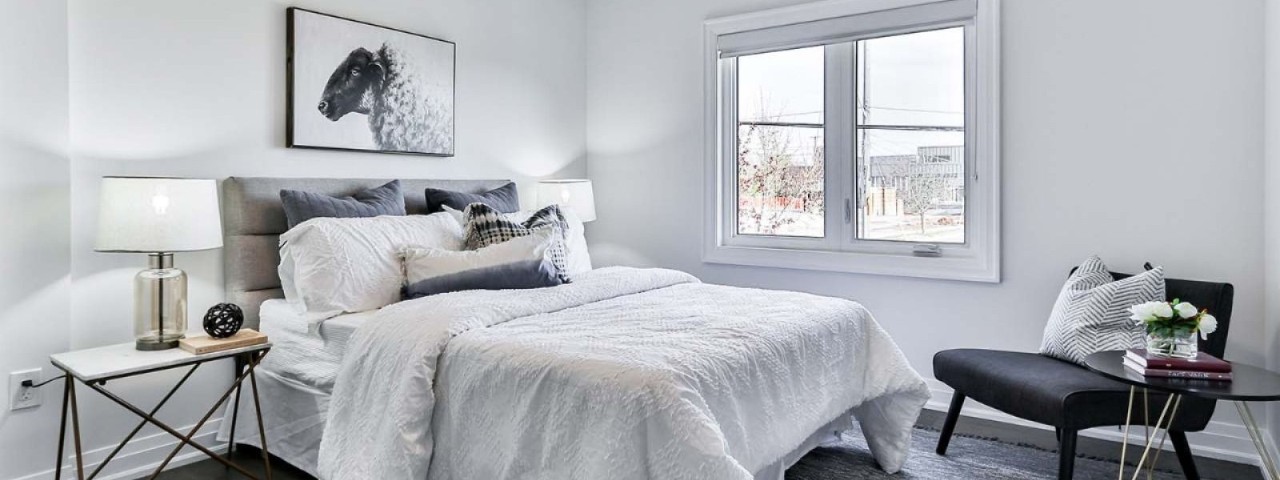 furnished bedroom with white linen and bedside table