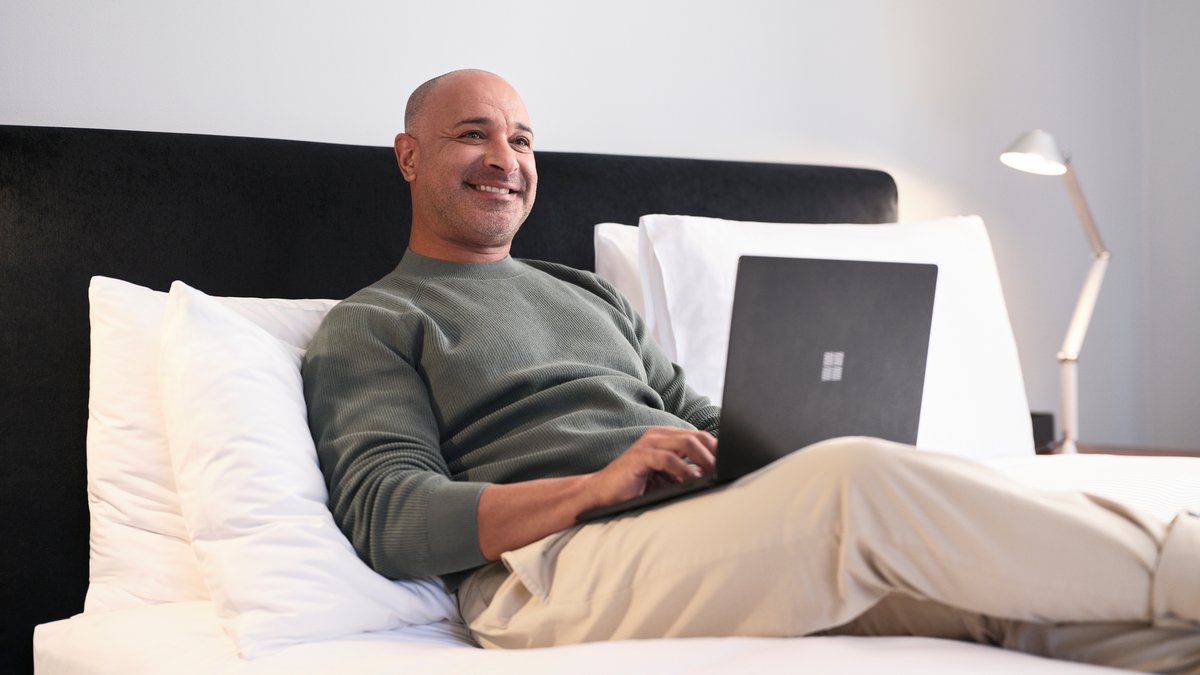 A man using a laptop on a bed