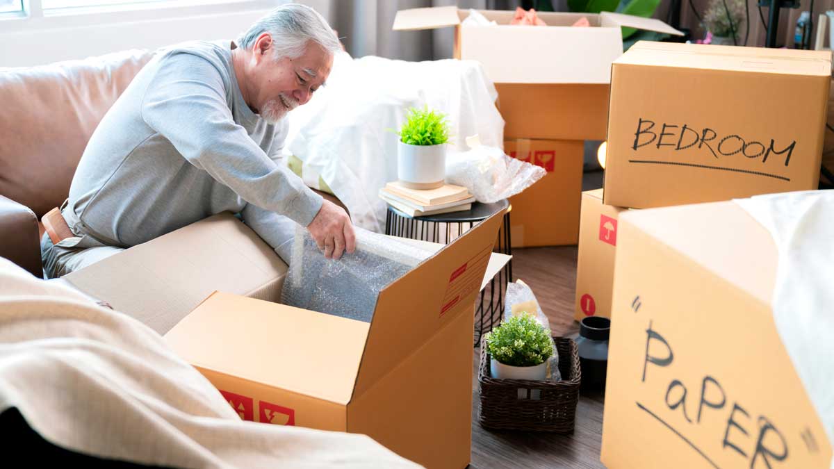 older man unpacking in new house