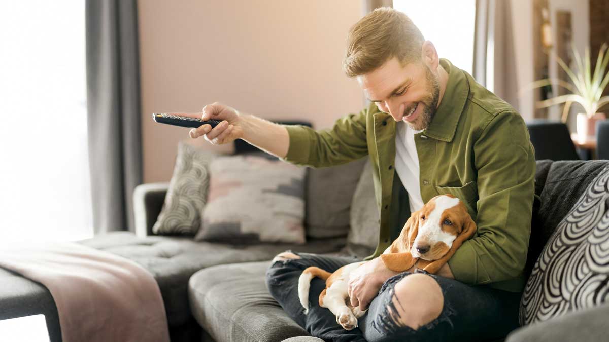 Man watching tv with dog