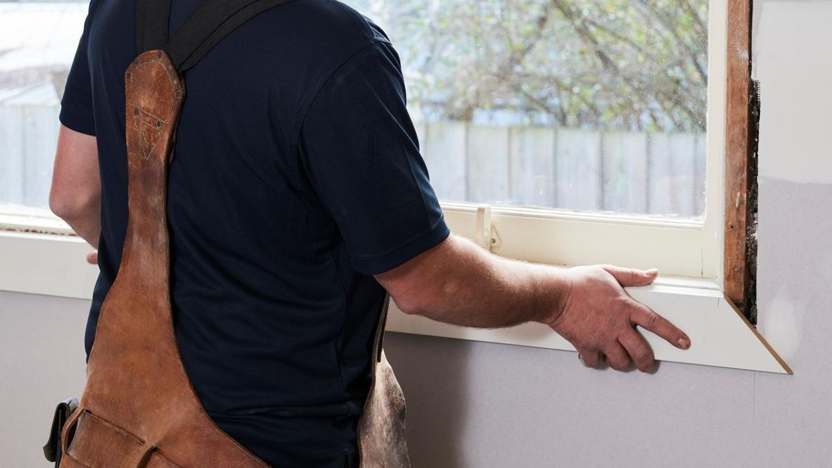 A tradesperson fixing a timber window frame