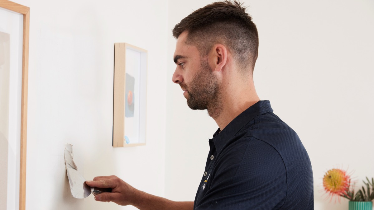RACV tradie doing plaster repair on wall