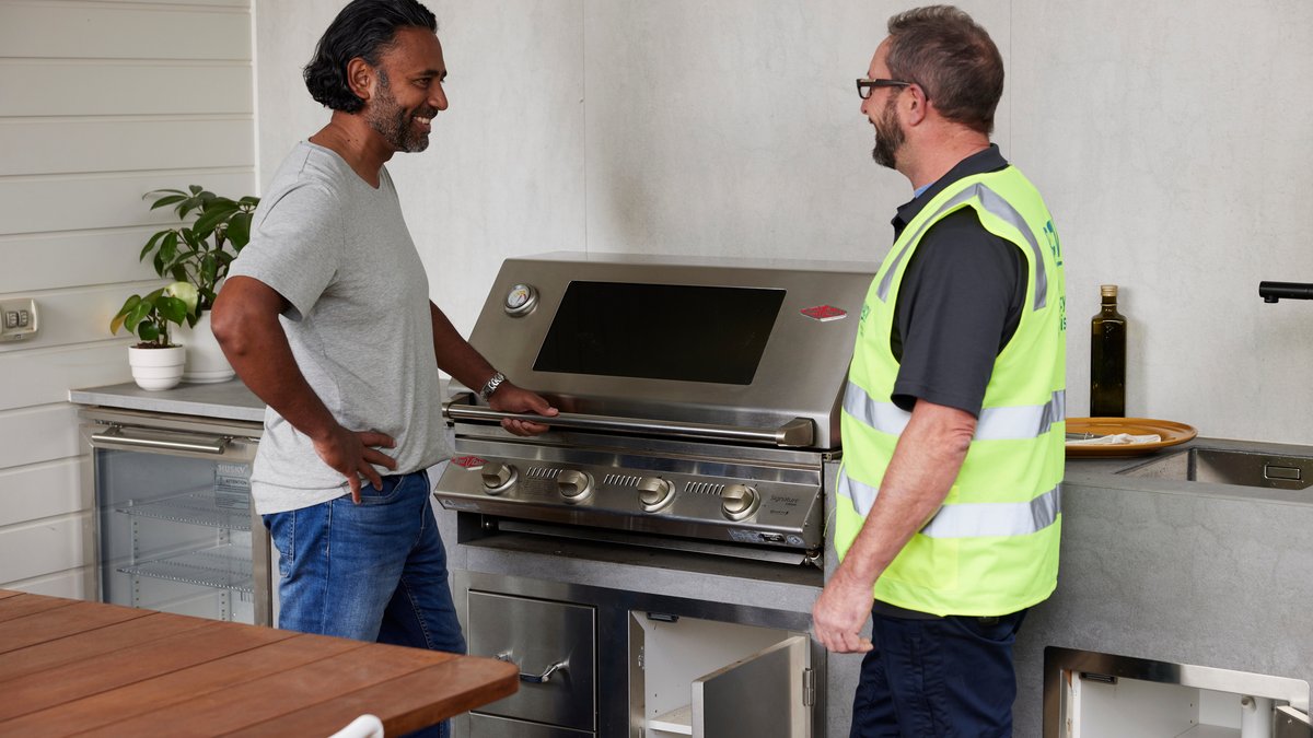 person cutting raw chicken on wooden chopping board